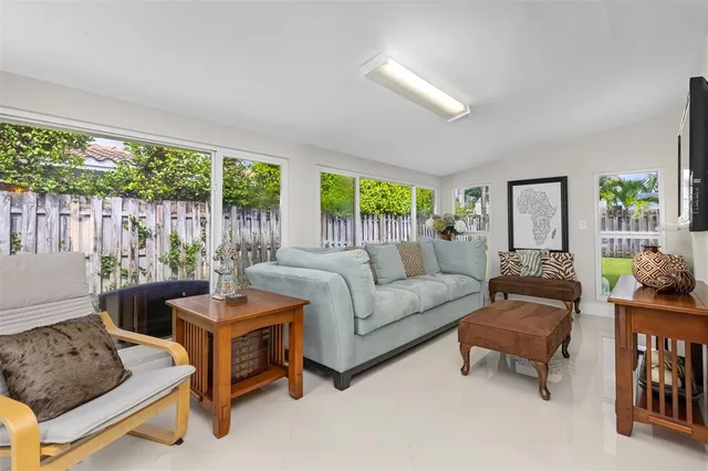 a living room with patio furniture and a large window