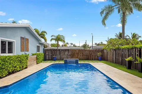 a view of a backyard with potted plants and wooden fence