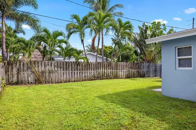 a view of a yard with wooden fence