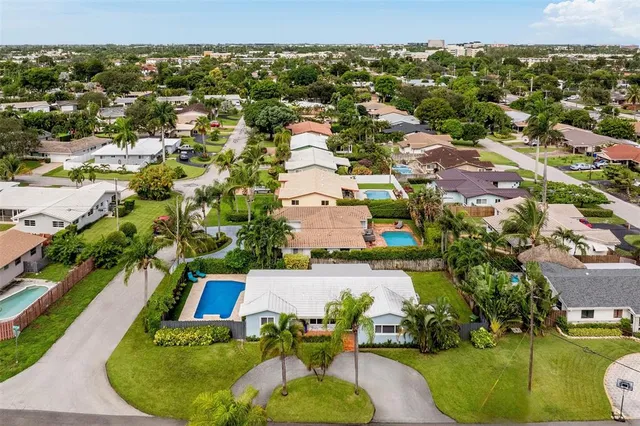 an aerial view of a house with a swimming pool and lake view