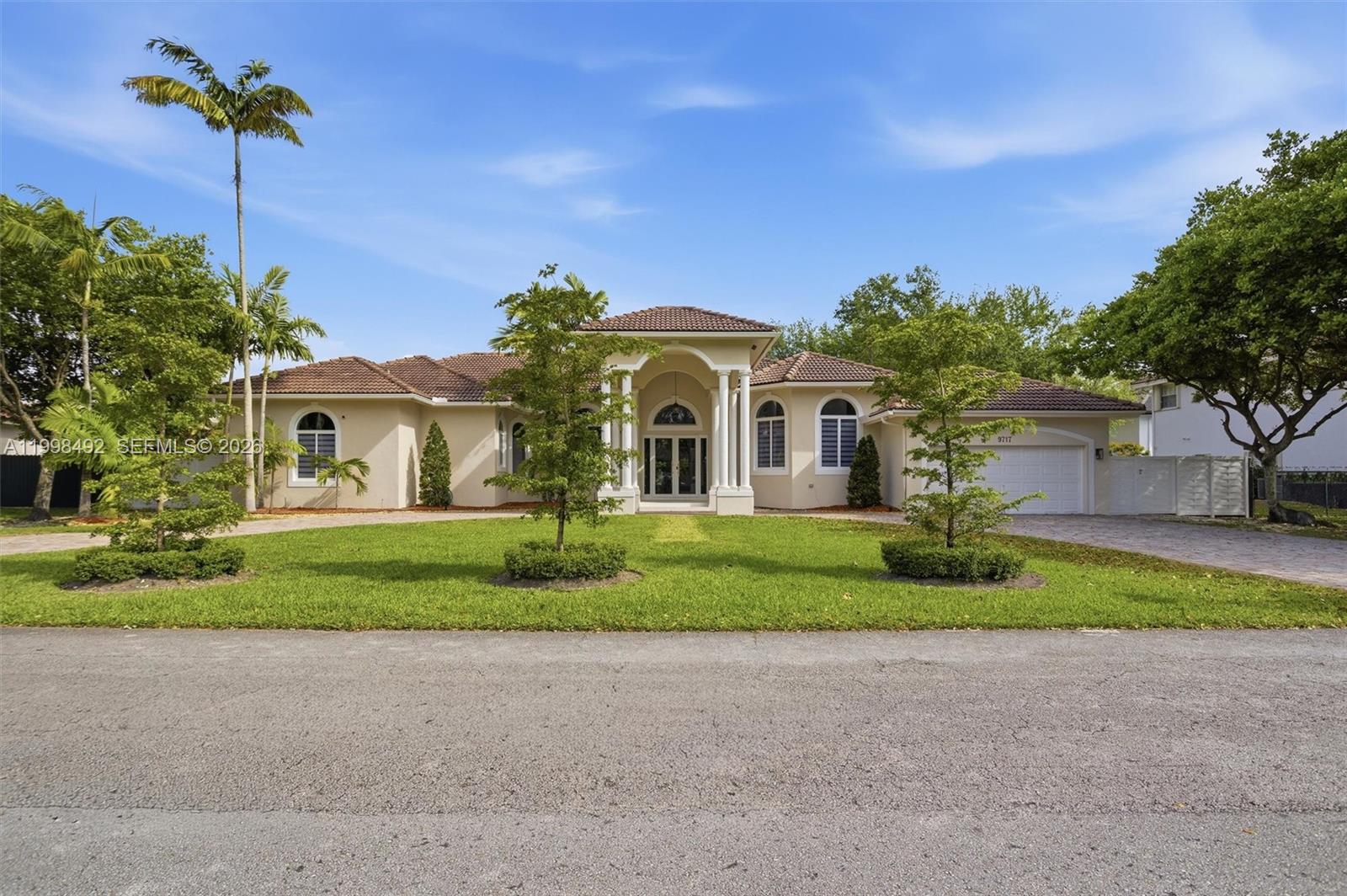 9717 Southwest 94th Terrace Miami, FL 33176 - Photo 2 of 63 a front view of a house with a garden and trees