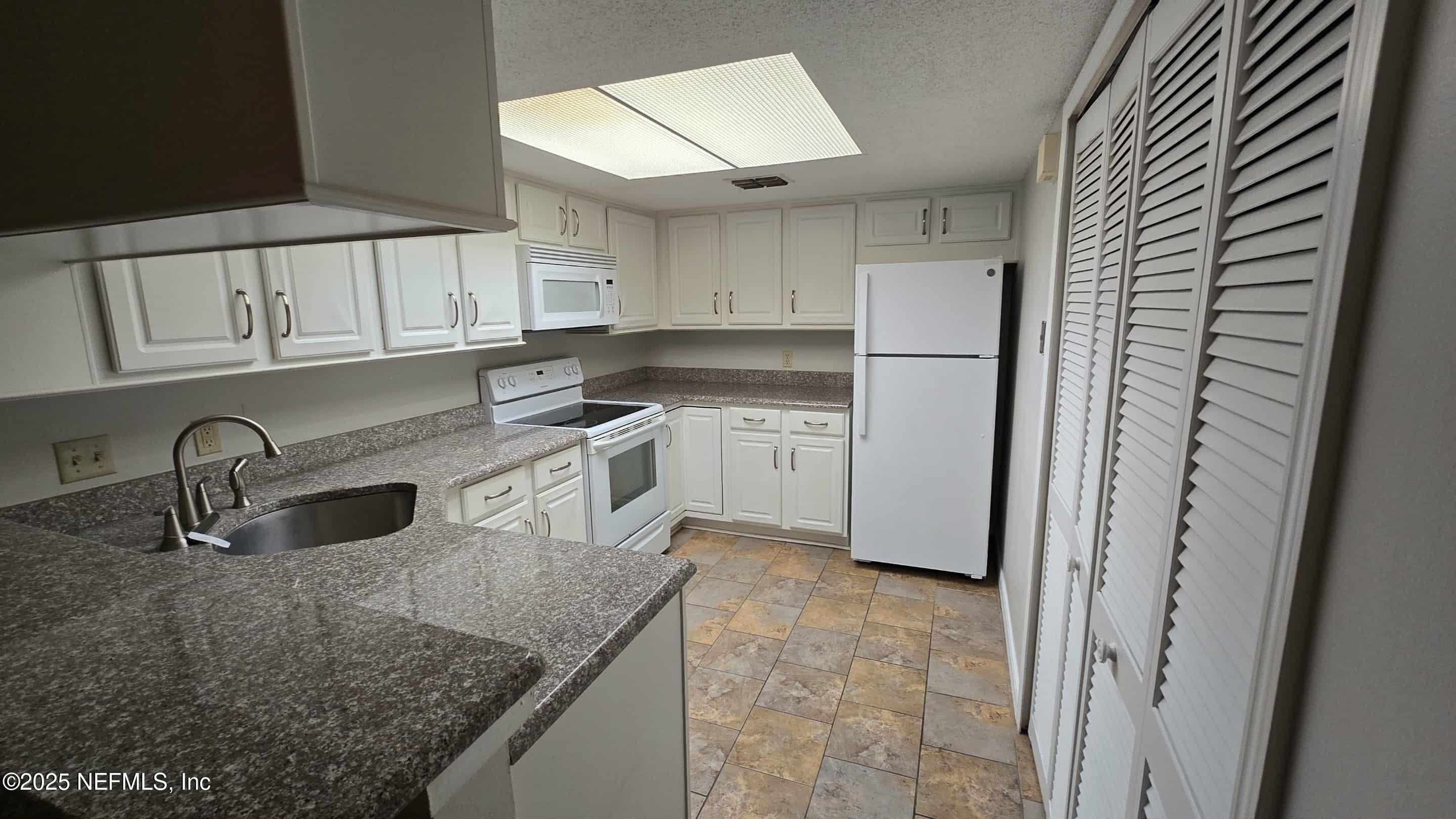 2302 East Challenger Court, Unit 2302 Jacksonville, FL 32233 - Photo 6 of 11 a kitchen with stainless steel appliances granite countertop a sink stove and refrigerator