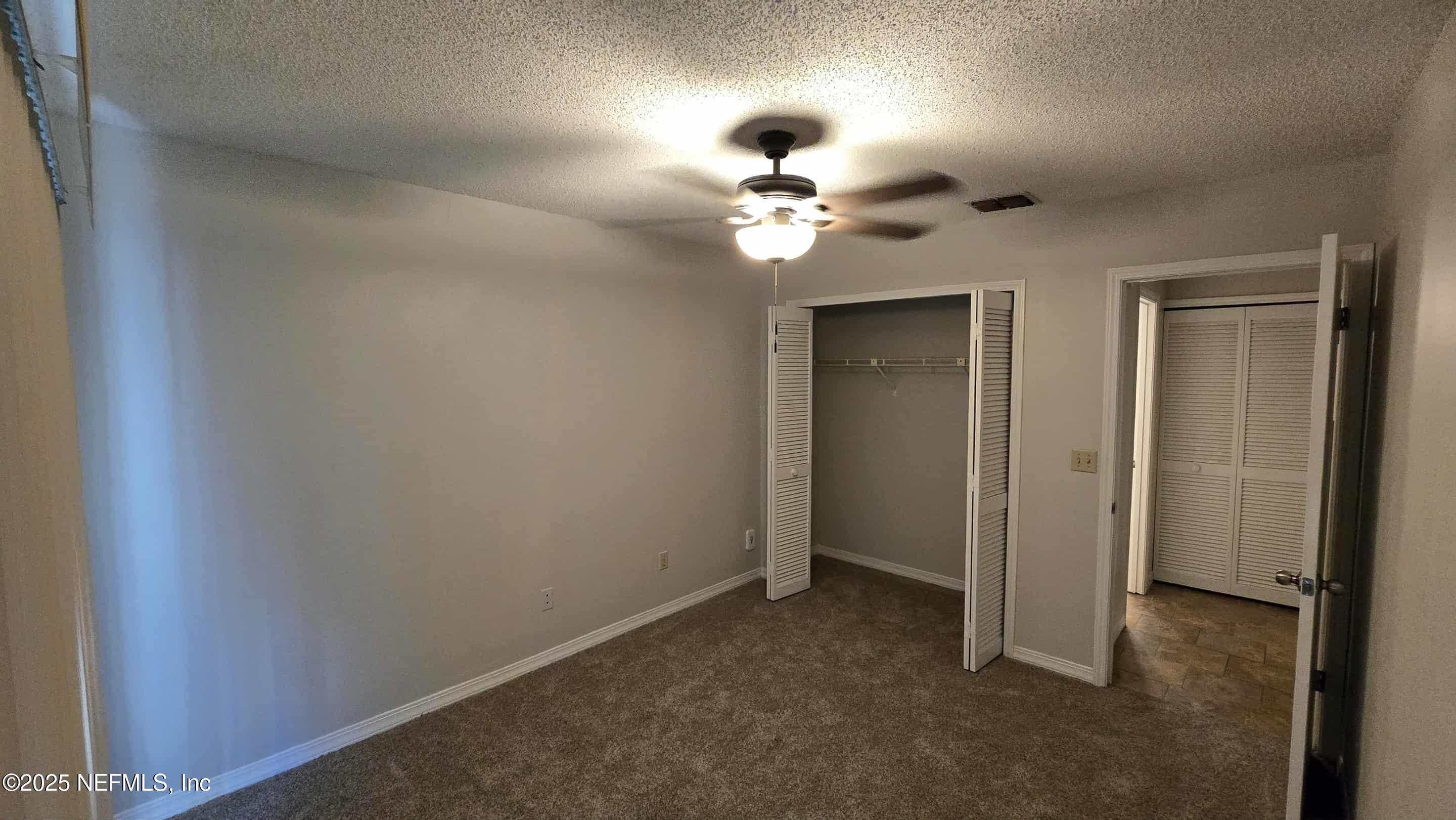 2302 East Challenger Court, Unit 2302 Jacksonville, FL 32233 - Photo 10 of 11 wooden floor in an empty room with a window