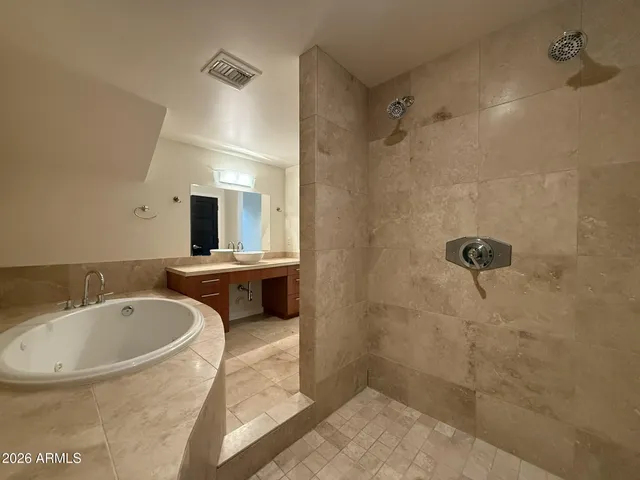 a bathroom with a tub a sink and a shower