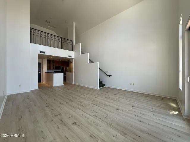 a view of empty room with wooden floor and fireplace
