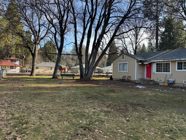 a view of a house with backyard and tree