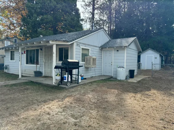 a view of a house with backyard and sitting area