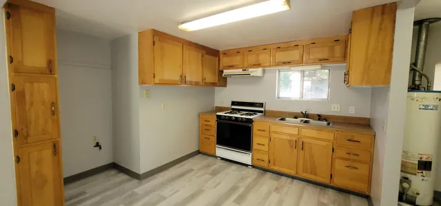 a kitchen with stainless steel appliances granite countertop a stove a sink and a refrigerator