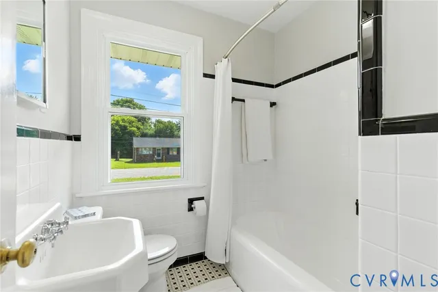 a white bath tub sitting next to a white sink and a shower