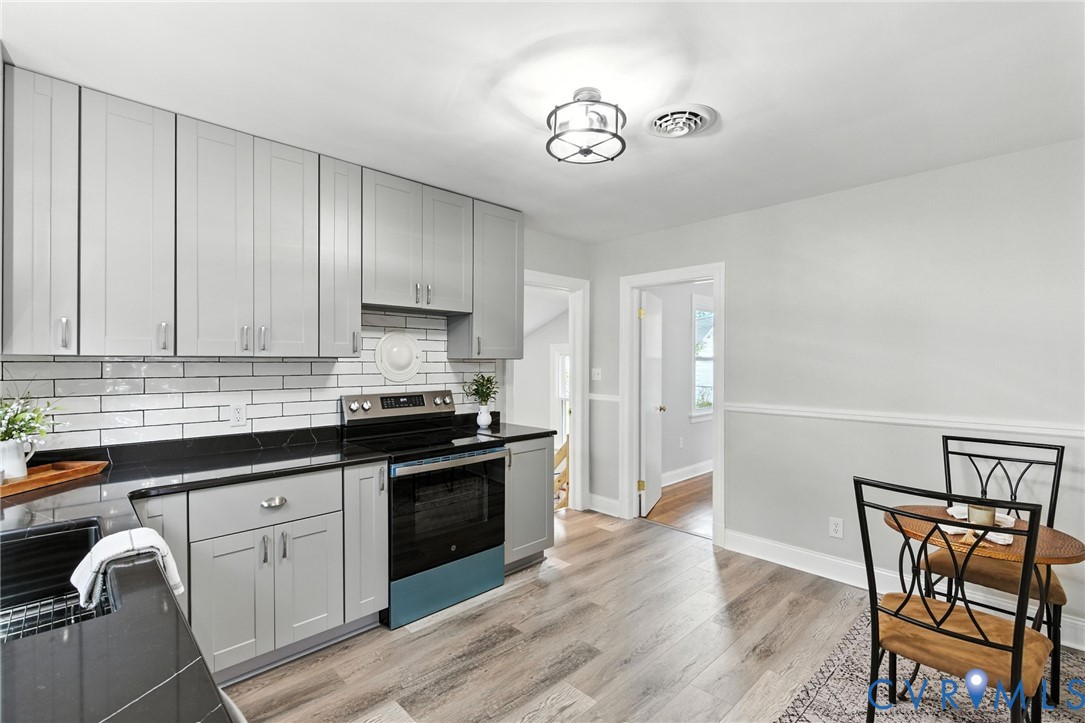 4825 Kinloch Lane Henrico, VA 23231 - Photo 4 of 28 a kitchen with granite countertop white cabinets and black appliances