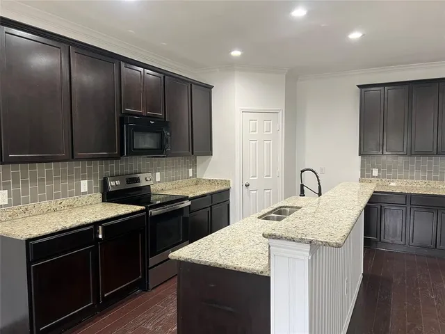 a kitchen with a sink stove and cabinets