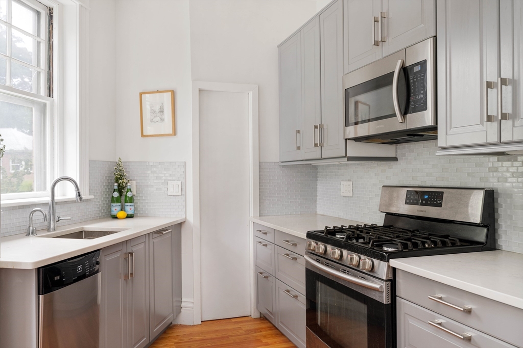 503 Boylston Street, Unit 4 Brookline, MA 02445 - Photo 5 of 16 a kitchen with stainless steel appliances white cabinets and a stove top oven