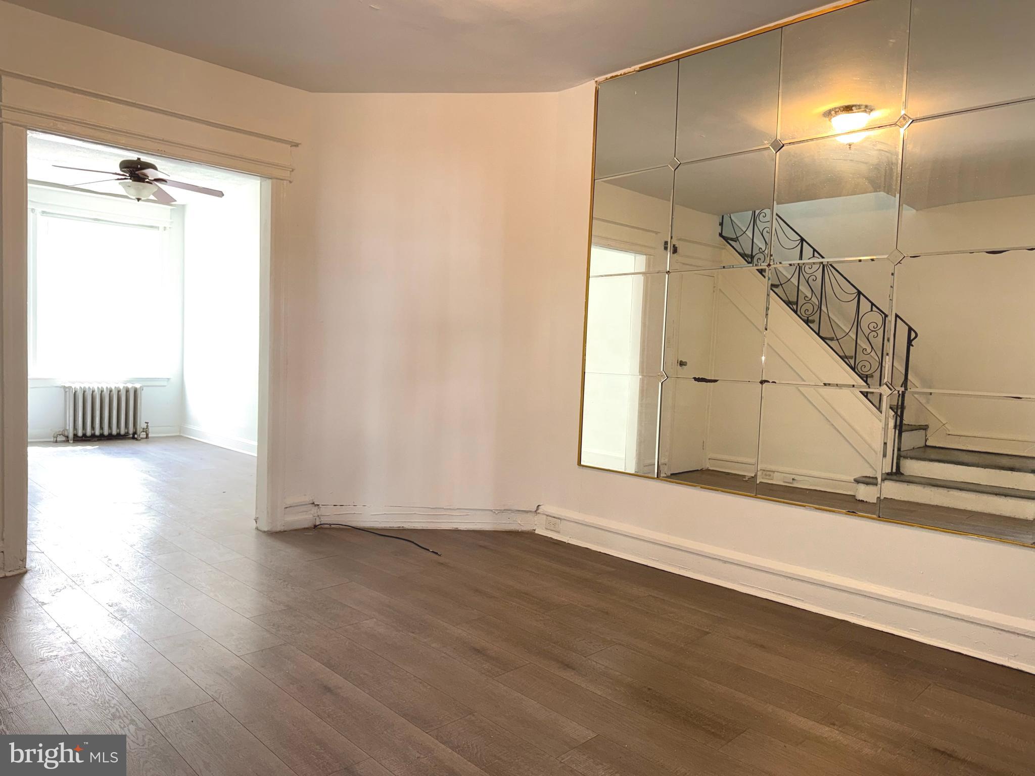 5756 Hunter Street Philadelphia, PA 19131 - Photo 4 of 16 a view of an empty room with wooden floor and a window