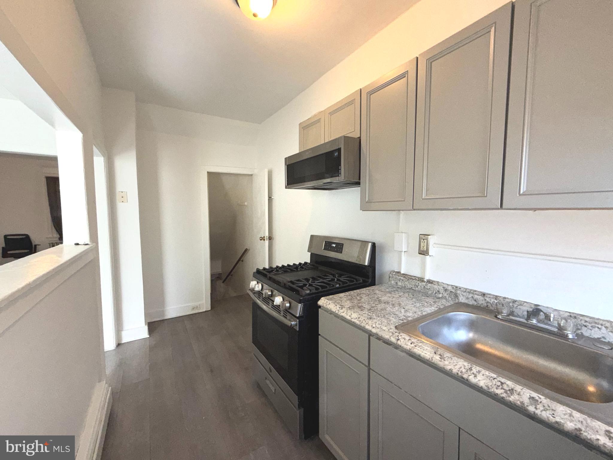 5756 Hunter Street Philadelphia, PA 19131 - Photo 8 of 16 a kitchen with granite countertop a sink and a stove top oven