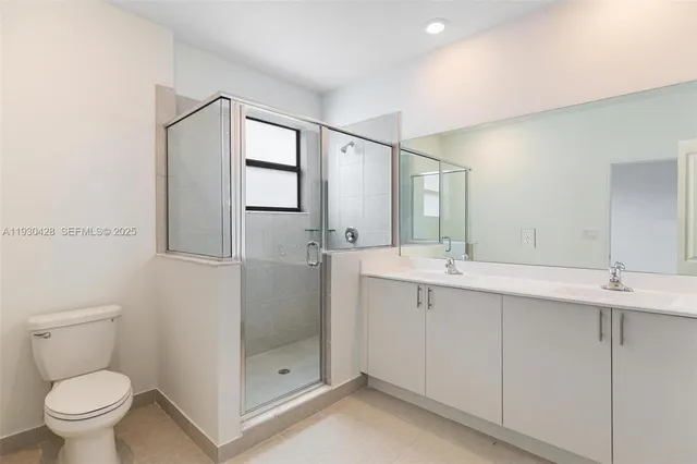 a bathroom with a toilet a sink a mirror and a shower