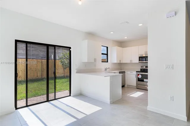 a open kitchen with a sink and white cabinets