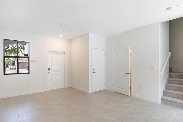 a view of an empty room with windows and closet