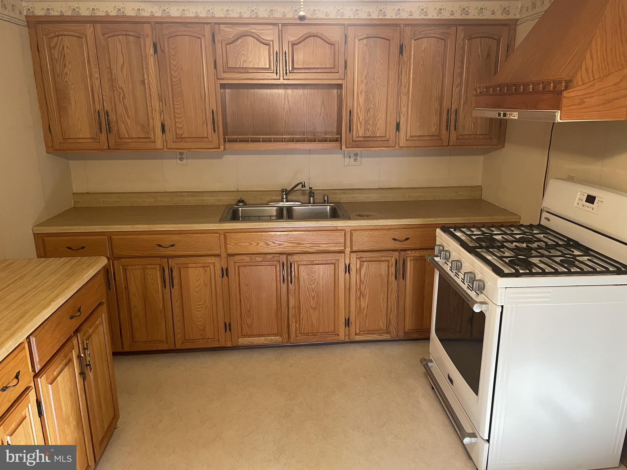 4420 West Denneys Road Dover, DE 19904 - Photo 15 of 36 a kitchen with stainless steel appliances granite countertop a stove a sink and a microwave