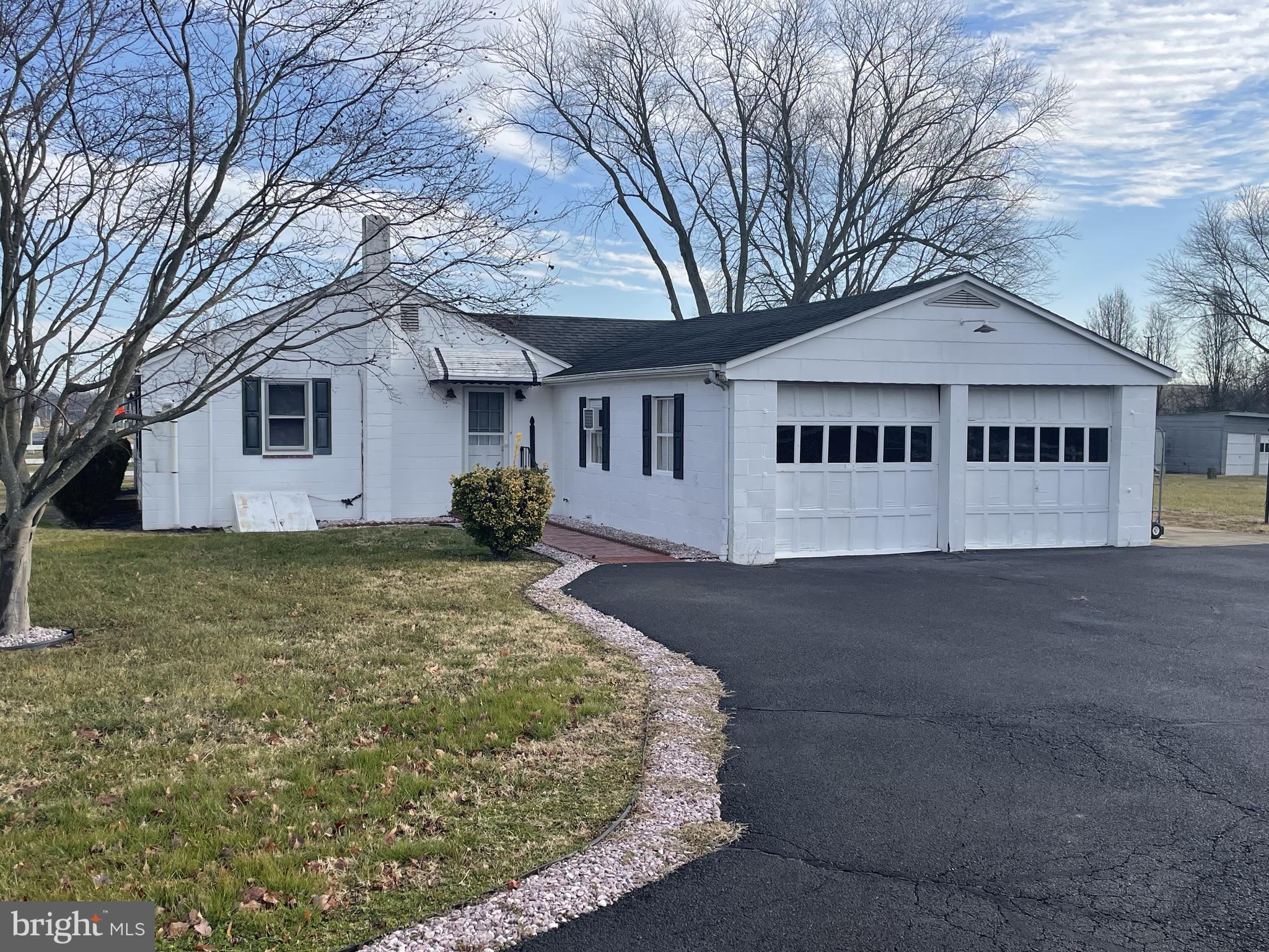 4420 West Denneys Road Dover, DE 19904 - Photo 5 of 36 a view of a white house with a large tree and wooden fence