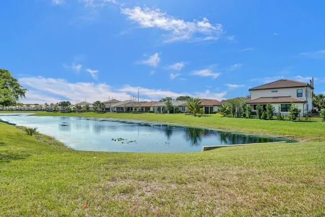 a sign board with flower plants and trees