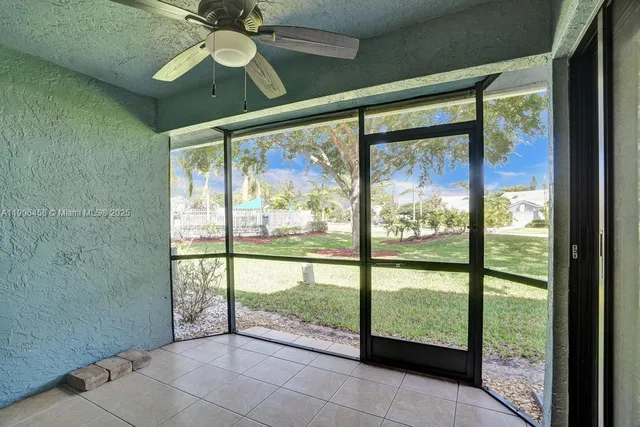 a view of an empty room and window ceiling fan