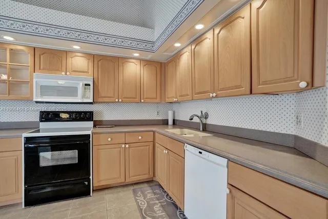 a kitchen with stainless steel appliances granite countertop a stove a sink and a white cabinets