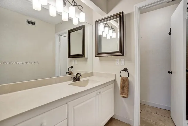 a bathroom with a sink a large mirror and a toilet