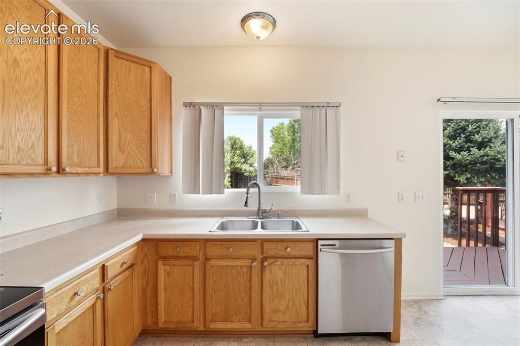 7904 Coffee Road Peyton, CO 80831 - Photo 13 of 48 Kitchen featuring light wood cabinetry, a dual-basin stainless steel sink, and light-toned countertops