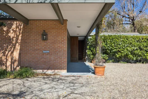 a view of a entryway door with potted plants