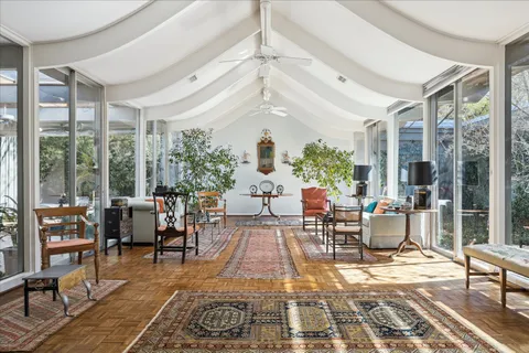 a view of living room filled with furniture and large windows