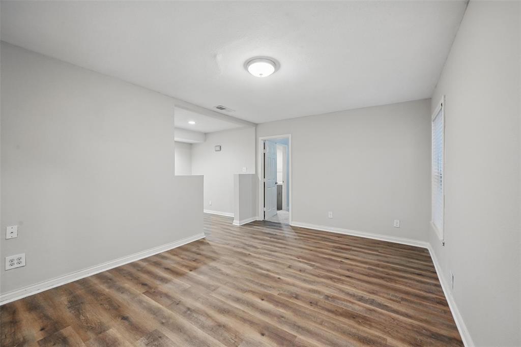 1003 Pecan Avenue Greenville, TX 75401 - Photo 13 of 25 a view of an empty room with wooden floor and a window
