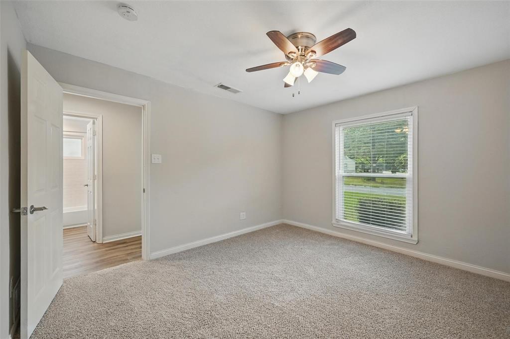 1003 Pecan Avenue Greenville, TX 75401 - Photo 16 of 25 a view of an empty room with window and a ceiling fan