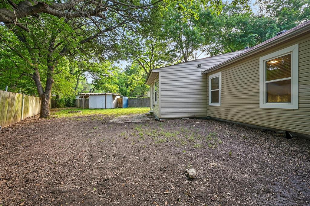1003 Pecan Avenue Greenville, TX 75401 - Photo 24 of 25 a view of a house with a yard and a large tree