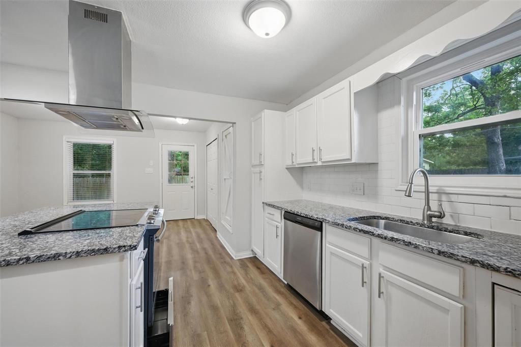 1003 Pecan Avenue Greenville, TX 75401 - Photo 4 of 25 a kitchen with granite countertop a sink stove and cabinets