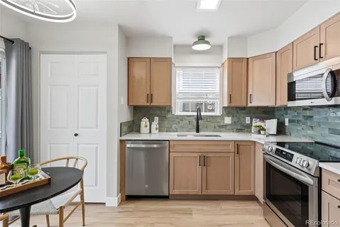 a kitchen with granite countertop a stove microwave and refrigerator