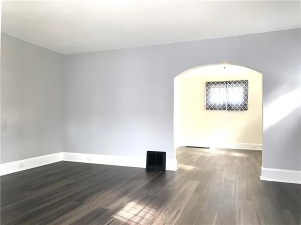 a view of a big room with wooden floor and windows