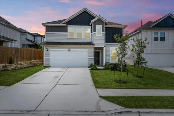 a front view of a house with a yard and garage
