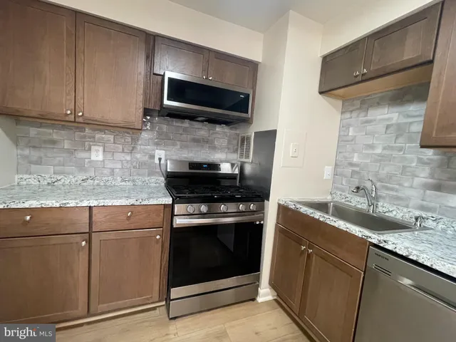 a kitchen with stainless steel appliances granite countertop a stove and a microwave