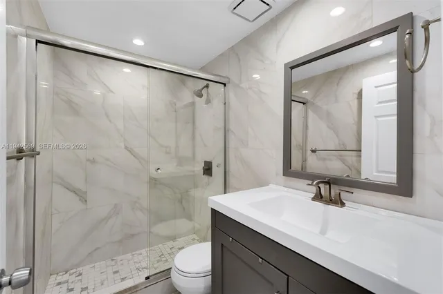 a bathroom with a sink a toilet and shower