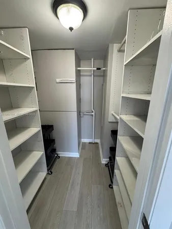 a view of walk in closet with empty racks