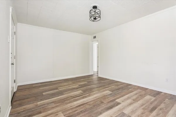 a view of a room with a white wall and wooden floor
