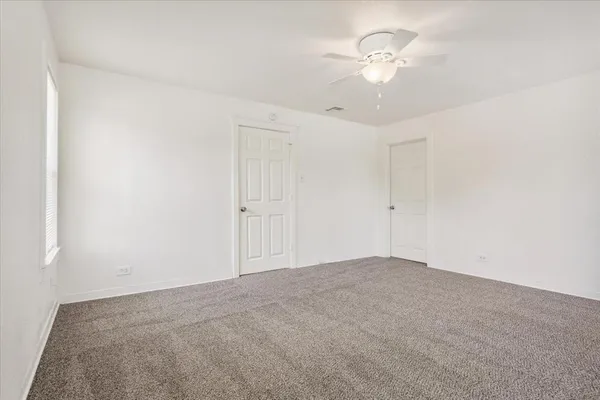 a view of an empty room with a ceiling fan
