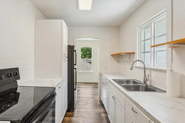 a kitchen with a sink and a stove top oven