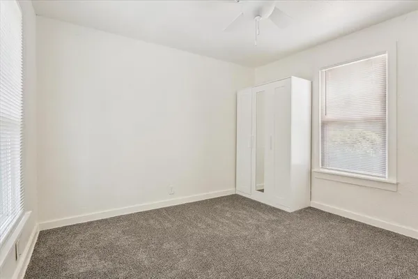 an empty room with windows and closet