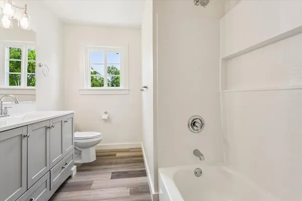 a bathroom with a toilet a sink a tub and a window