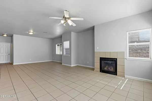 an empty room with windows and fireplace