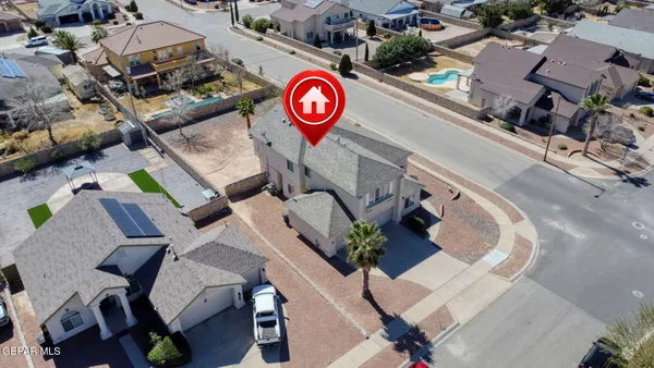 an aerial view of a residential house with swimming pool and outdoor seating
