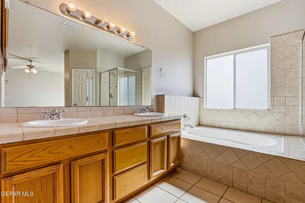 a spacious bathroom with a granite countertop sink a mirror and a bathtub