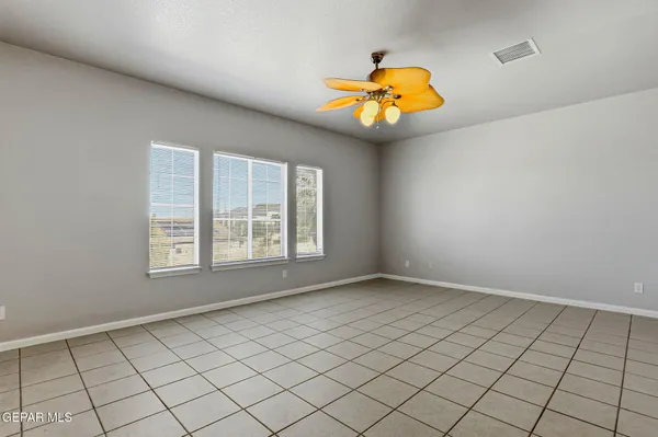an empty room with windows and fan