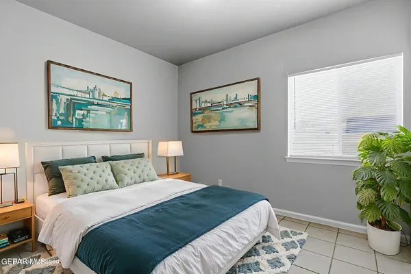 a bedroom with a large bed and a potted plant